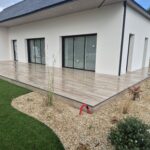Terrasse carrelée en dalles sur plots effet bois moderne devant maison contemporaine à Mauron en Bretagne terrasse carrelage effet bois, terrasse moderne Bretagne, aménagement extérieur Ille-et-Vilaine, terrasse Saint-Méen-le-Grand, pose carrelage extérieur 35, paysagiste Bretagne, terrasse contemporaine, aménagement jardin gravier, artisan terrasse Bretagne, Yann Jegouzo