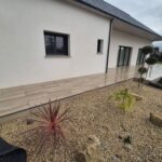 Terrasse carrelée en dalles sur plots effet bois moderne devant maison contemporaine à Mauron en Bretagne terrasse carrelage effet bois, terrasse moderne Bretagne, aménagement extérieur Ille-et-Vilaine, terrasse Saint-Méen-le-Grand, pose carrelage extérieur 35, paysagiste Bretagne, terrasse contemporaine, aménagement jardin gravier, artisan terrasse Bretagne, Yann Jegouzo