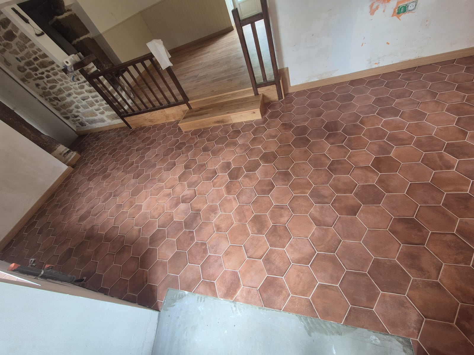 Pose de carrelage hexagonal imitation terre cuite dans une maison à Ménéac (56), réalisée par Yann JEGOUZO, artisan carreleur à Saint-Méen-le-Grand en Ille-et-Vilaine, Bretagne. Rénovation intérieure avec carrelage hexagonal grand format et finitions soignées.